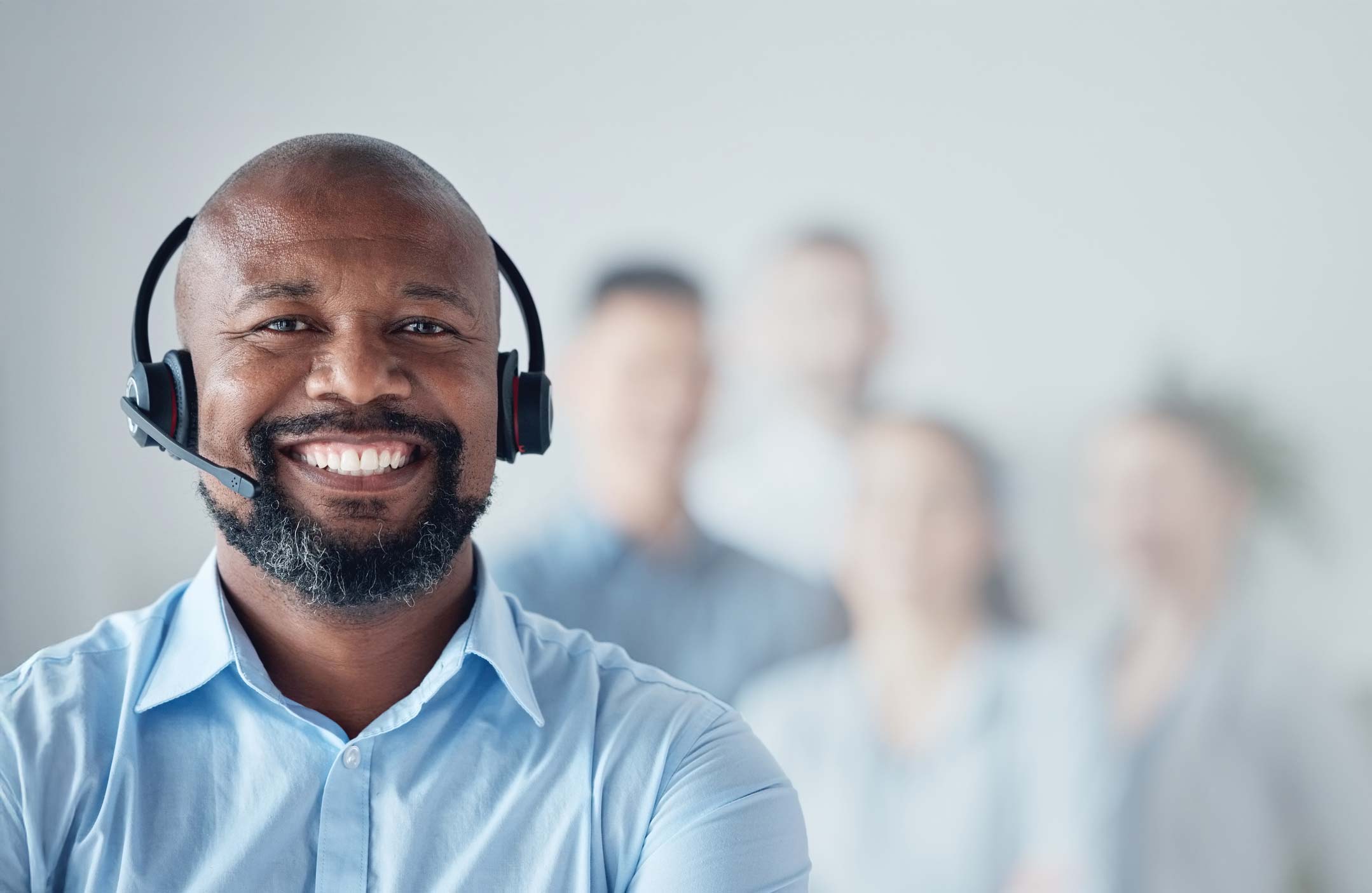 Man in blue shirt and a big smile with headset